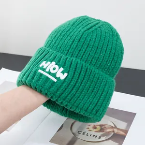 Detailaufnahme der grünen Rippstrickmütze mit weißem HIOW-Logoaufdruck für Herren und Damen