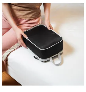 Detail of travel packing cube with breathable mesh top and gray handle held by a person