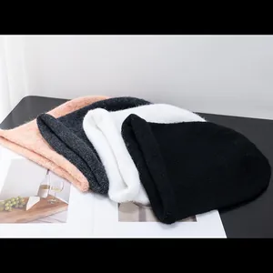 Détail de bonnets en laine d'alpaga en couleurs noir blanc gris et orange