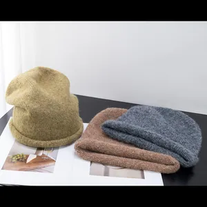 Gros plan de bonnets en laine d'alpaga en couleurs olive, marron et gris foncé