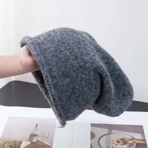 Gros plan du bonnet en laine d'alpaga gris foncé montrant la texture douce et duveteuse