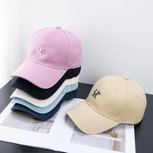 Multi-colored embroidered baseball caps with HOPE logo displayed on a wooden desk