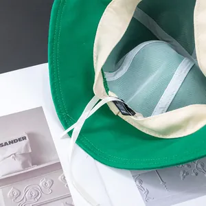 Cappello da pescatore verde in tela con coulisse regolabile e fodera interna crema