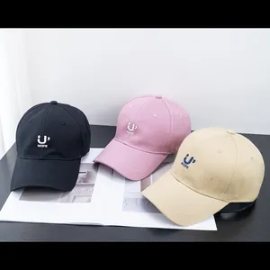 Detail of embroidered 'U' HOPE logo on cotton baseball caps in black, pink and beige