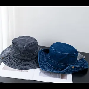 Détail de bobs en denim délavé avec surpiqûres blanches et boutons métalliques