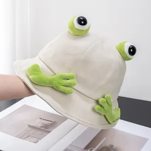 Dettaglio di un cappello a secchiello a rana con occhi in peluche 3D e mani in tela beige