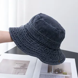 Détail du chapeau bob en denim délavé avec coutures renforcées et œillets en cuivre