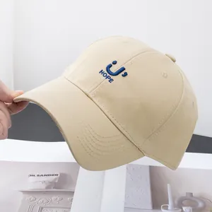 Detail of blue HOPE embroidery on a khaki cotton baseball cap with fine stitching