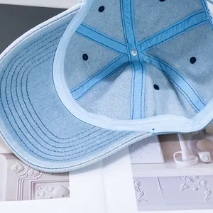 Detailed macro view of the inner lining and stitching of a light blue denim baseball cap