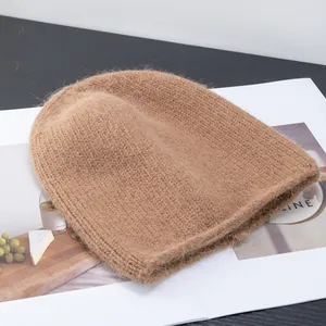 Dettaglio del berretto in maglia caramello caldo con morbida trama in mohair su rivista