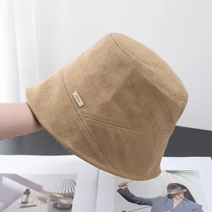 Close-up of the textured cotton fabric and jijiino brand label on the camel bucket hat