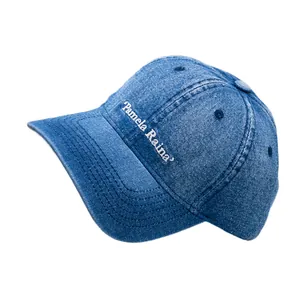 Classic blue washed denim baseball cap with Pamela Raina embroidery in a front view