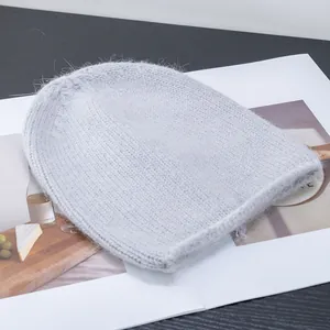 Dettaglio del berretto in maglia angora azzurro con morbida consistenza pelosa su un libro
