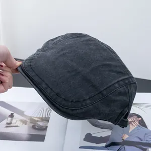 Detail van de donkergrijze gewassen katoenen stof en stiksels op een retro flat cap