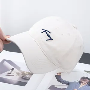 Detail of cream cotton baseball cap with navy blue 'Funny' handwriting embroidery