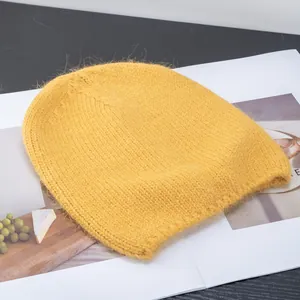 Dettaglio ravvicinato del berretto in maglia di mohair giallo con trama soffice e morbida