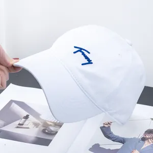Detailed embroidery of navy blue lettering on a high-quality white cotton baseball cap