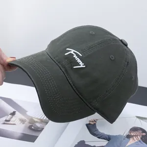 Detail shot of Funny embroidery on dark green cotton twill baseball cap fabric