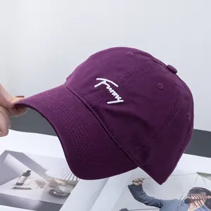 Detailed close-up of white Funny embroidery on premium purple cotton twill baseball cap