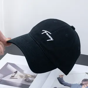 Detail of black cotton baseball cap featuring white Funny script embroidery on the front