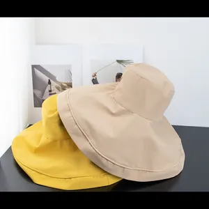 Detail of yellow and beige wide brim sun hats for women with UV protection fabric