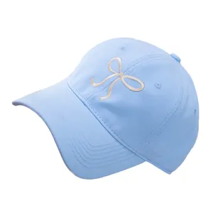 Sky blue cotton baseball cap with white embroidered bow and adjustable soft crown