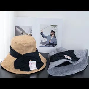 Detailed texture of woven UV protection sun hats with decorative black ribbon bows