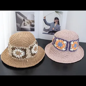 Detailed macro view of crochet floral pattern on foldable straw bucket sun hats