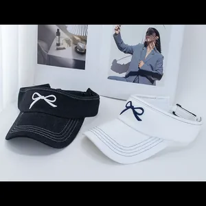 Denim and canvas sun visors with embroidered bows in black and white styles