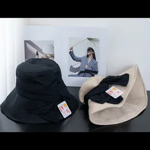 Detail of UV protection sun hat with large bow and tag showing 99% UV block rate
