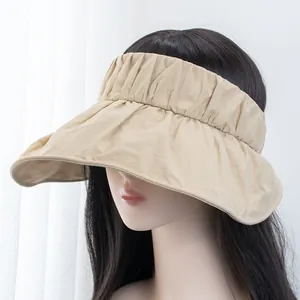 Detail of pleated beige sun hat with wide brim showing UV protection fabric and headband style