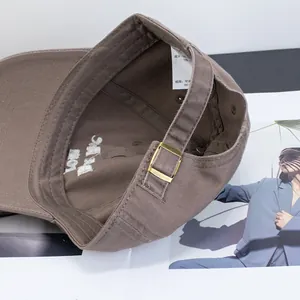 Internal detail of a soft dusty pink cotton baseball cap with embroidery and metal buckle