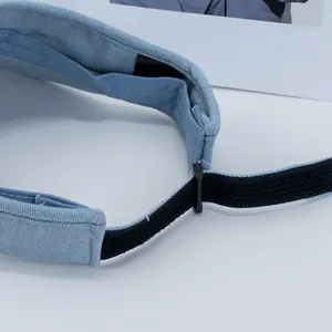 Detail of adjustable elastic back strap on a light blue denim sun visor hat