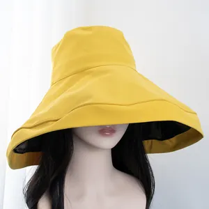 Detail view of large brim yellow sun hat with black UV protection lining and fabric texture