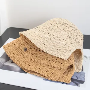 Eleganti cappelli a secchiello traforati in paglia intrecciata beige e kaki per il sole