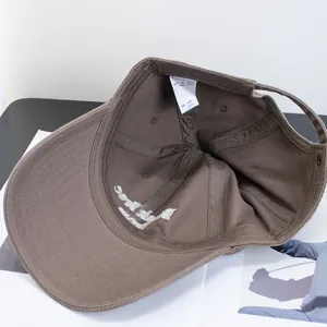 Detail view of cotton baseball cap interior with adjustable strap and 100% cotton label