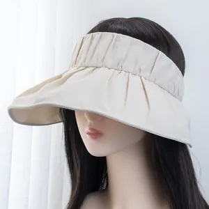Detailed view of cream wide-brim UV sun visor with pleated fabric and wavy edge design