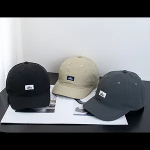 Trois casquettes de baseball minimalistes en noir, kaki et gris foncé avec patch logo