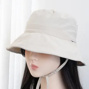 Detail of off-white sun hat showing diamond quilted brim and adjustable wind strap