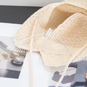 Close-up of cream straw sun hat interior showing sweatband and fine woven texture