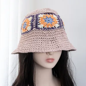 Detail of pink hand-crocheted straw bucket hat with colorful granny square floral patterns