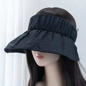Detail view of the wide pleated brim and elastic headband of the black sun visor hat