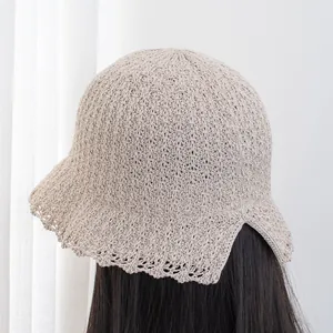 Detail of knitted sun hat featuring delicate scalloped edges and rear split opening