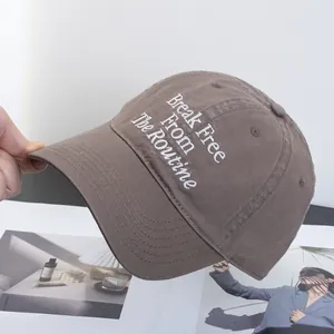 Detail of embroidery Break Free From The Routine on a brown cotton baseball cap