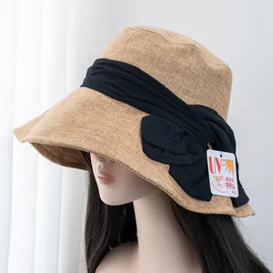 Detail of khaki straw sun hat with black bow and UV 99% protection certification tag