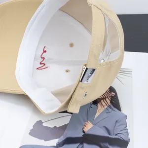 Close-up of khaki cotton baseball cap showing internal sweatband and metal adjustment buckle