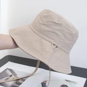 Detail view of beige sun hat featuring quilted stitching and adjustable windproof drawstring