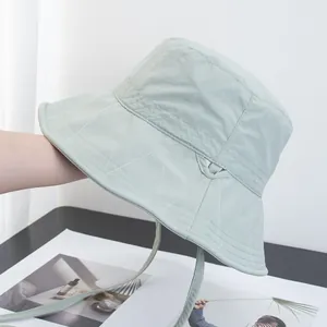 Close-up of mint green sun hat with white wave stitching and matching windproof drawstring