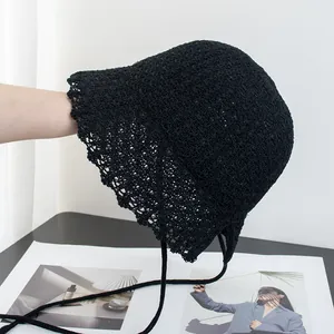Detail of black crochet straw bucket hat with lace trim and adjustable ties for women