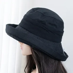 Detail showing the fine black straw texture and decorative ribbon of the wide brim sun hat